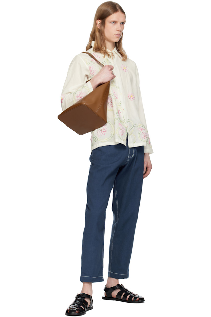 Hand-woven semi-sheer cotton double gauze shirt. Floral graphic pattern embroidered throughout. 

· Spread collar 
· Button closure
· Buttoned barrel cuffs

Supplier color: White