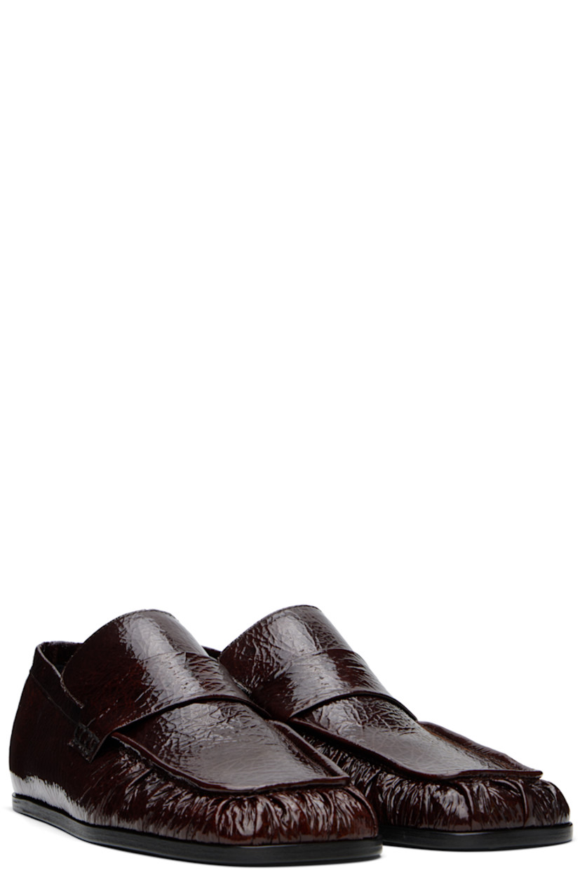 Hand-stitched crinkled patent goatskin loafers in burgundy.

· Gathering at square moc toe
· Strap at vamp
· Nappa leather insole and lining
· Polished calfskin sole with rubber injections

Supplier color: Dark earth