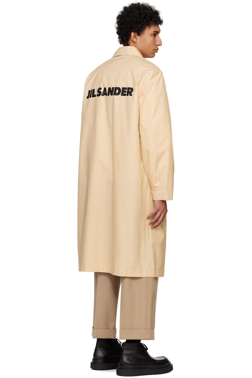 Plain-woven cotton coat. 

· Spread collar
· Press-stud closure
· Welt pockets
· Press-stud fastening at cuffs
· Logo printed at back 
· Storm flap at interior

Supplier color: Dark sand