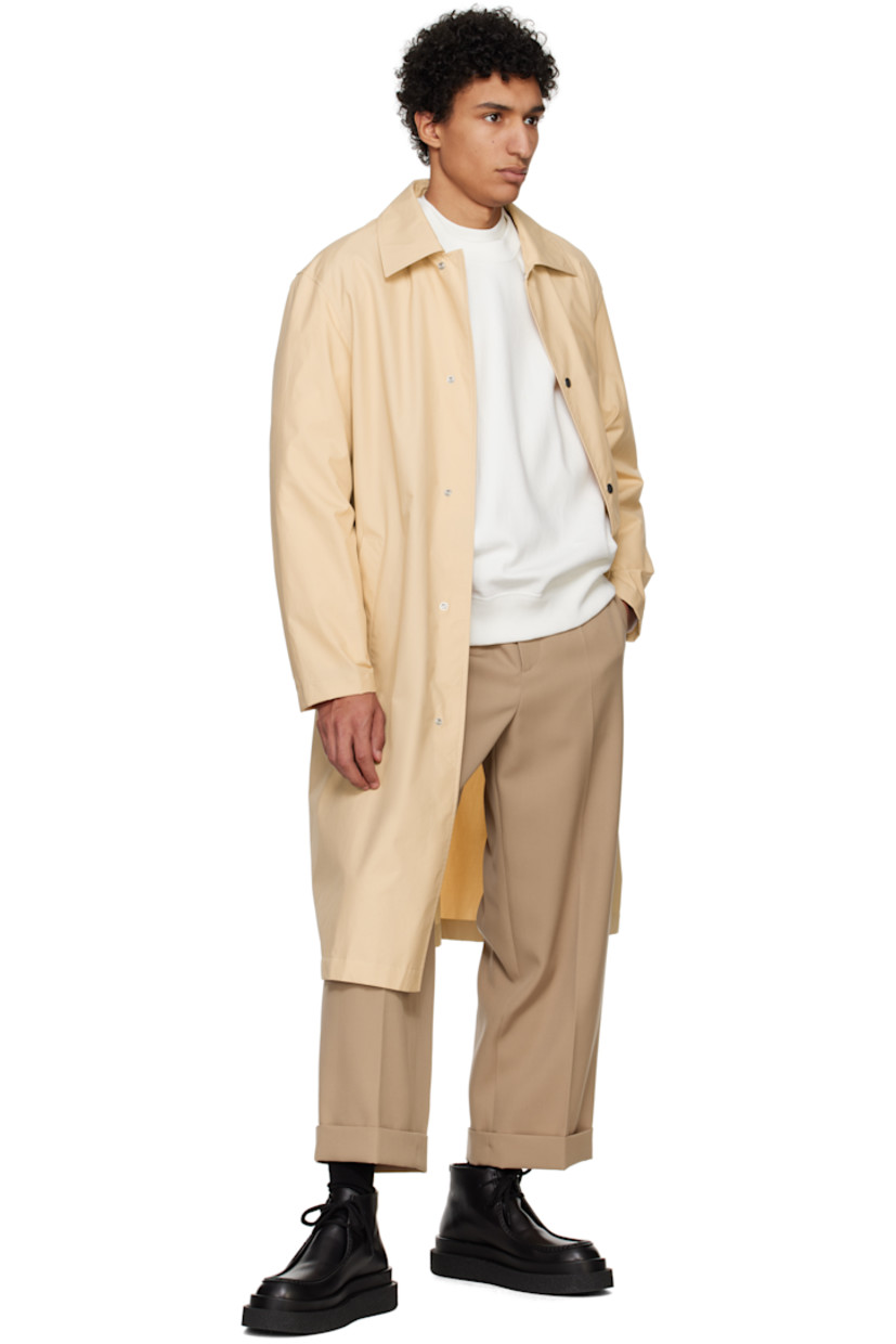 Plain-woven cotton coat. 

· Spread collar
· Press-stud closure
· Welt pockets
· Press-stud fastening at cuffs
· Logo printed at back 
· Storm flap at interior

Supplier color: Dark sand