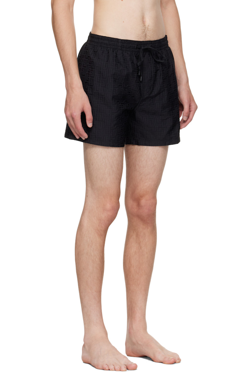 Twill swim shorts.

· Jacquard logo graphic pattern throughout 
· Drawstring at elasticized waistband 
· Three-pocket styling
· Mock fly 
· Grommets at back waist
· Mesh brief-style lining 

Supplier color: Black