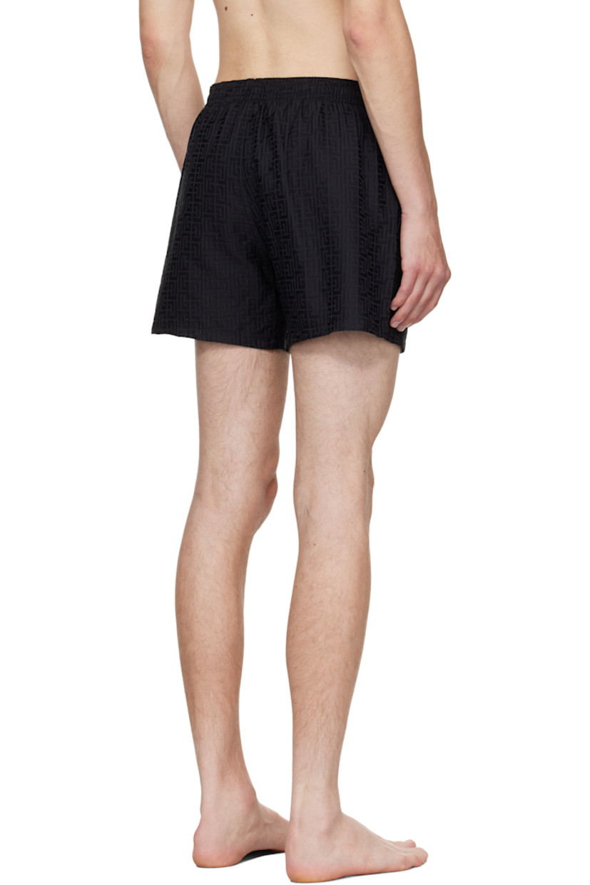 Twill swim shorts.

· Jacquard logo graphic pattern throughout 
· Drawstring at elasticized waistband 
· Three-pocket styling
· Mock fly 
· Grommets at back waist
· Mesh brief-style lining 

Supplier color: Black