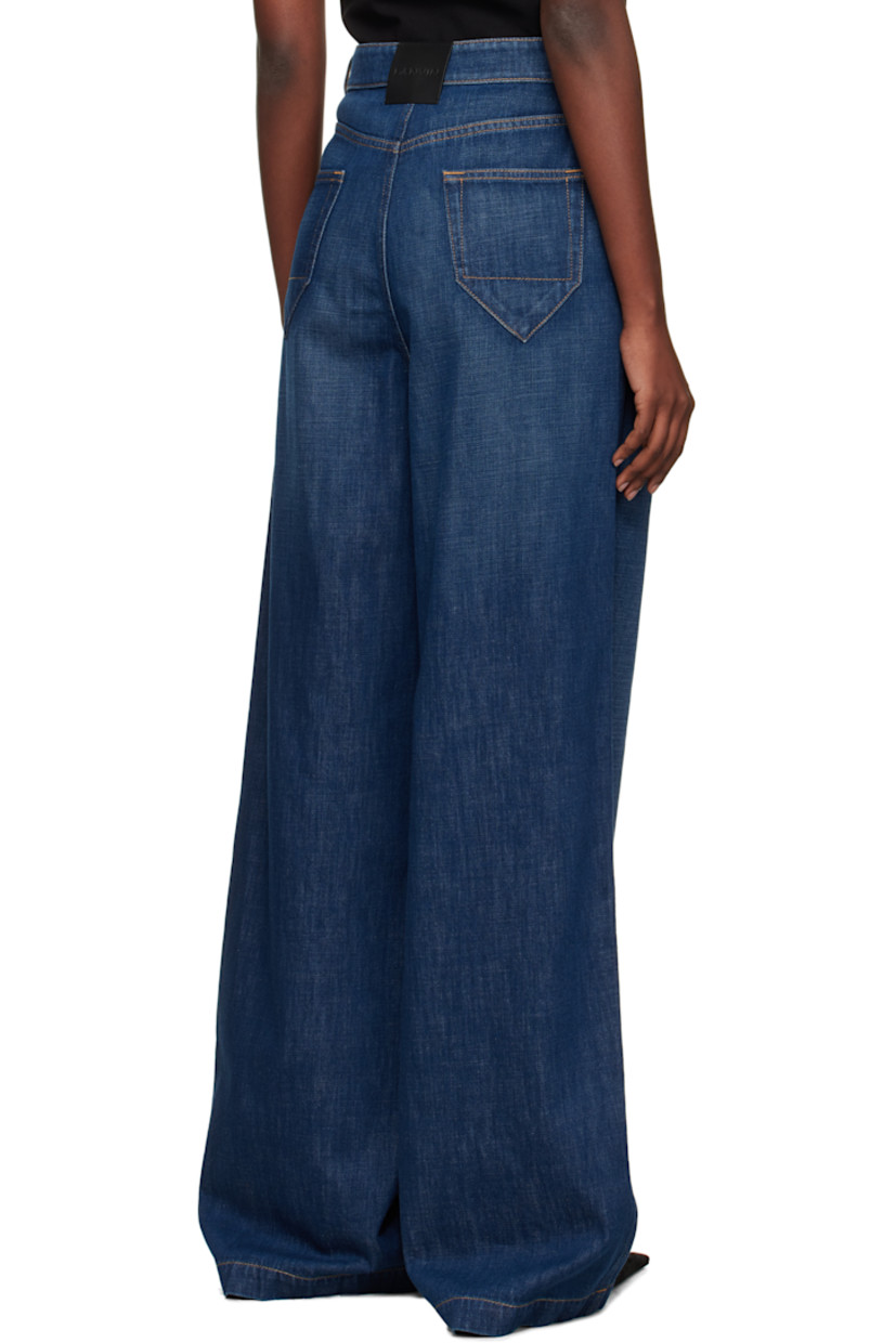 Hand-washed non-stretch denim jeans. 

· Wide-leg
· Subtle fading throughout
· Belt loops
· Four-pocket styling
· Zip fly
· Pleats at front 
· Creased legs
· Leather logo patch at back waistband
· Horn hardware
· Contrast stitching in tan

Supplier color: Medium blue