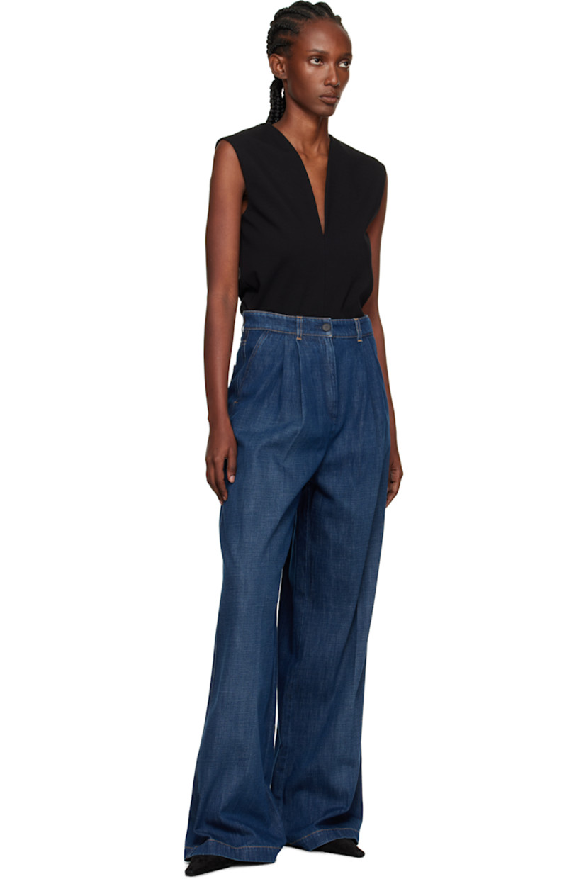 Hand-washed non-stretch denim jeans. 

· Wide-leg
· Subtle fading throughout
· Belt loops
· Four-pocket styling
· Zip fly
· Pleats at front 
· Creased legs
· Leather logo patch at back waistband
· Horn hardware
· Contrast stitching in tan

Supplier color: Medium blue