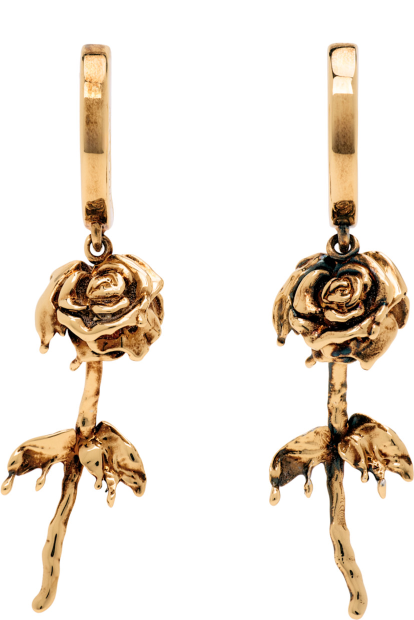 Pair of hoop earrings in antiqued gold-tone brass.

· Floral charm at drop
· Hinged-post fastening
· H1.75" x W0.5"

Supplier color: Antique gold