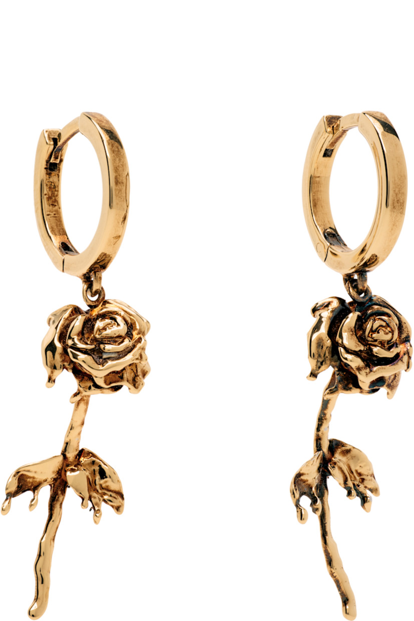 Pair of hoop earrings in antiqued gold-tone brass.

· Floral charm at drop
· Hinged-post fastening
· H1.75" x W0.5"

Supplier color: Antique gold