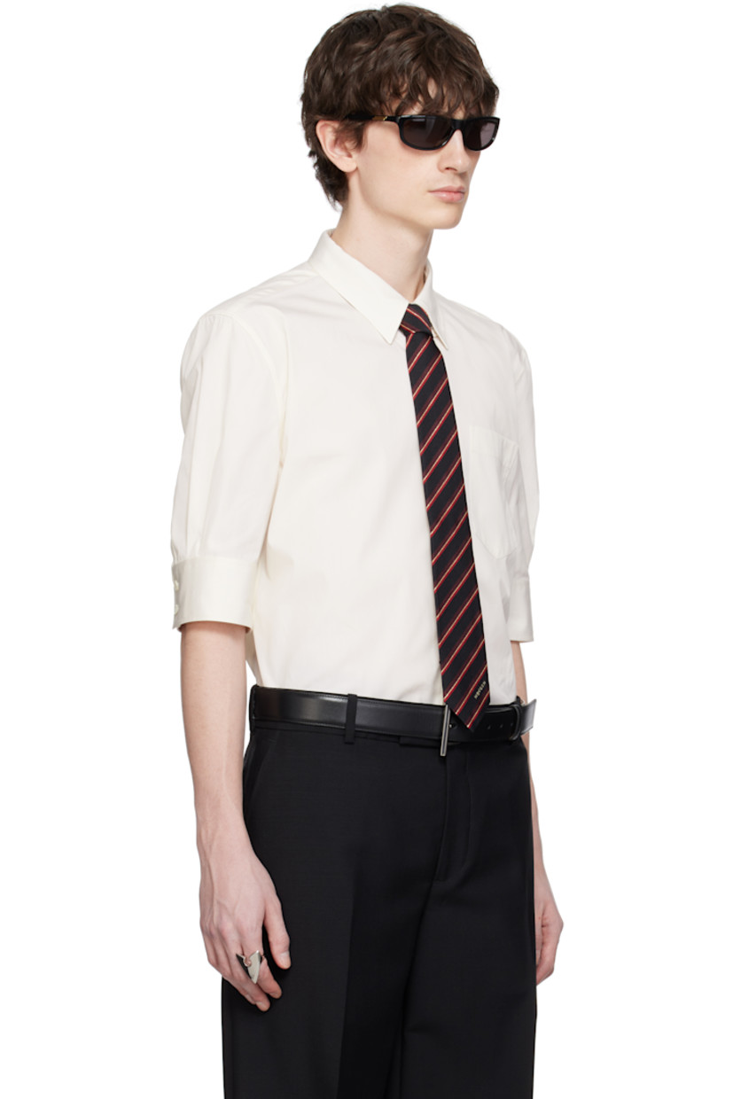 Cotton poplin shirt.

· Spread collar with concealed button-down fastening
· Button closure
· Patch pocket
· Shirttail hem
· Buttoned barrel cuffs
· Twin pleats at yoke 

Supplier color: Ivory