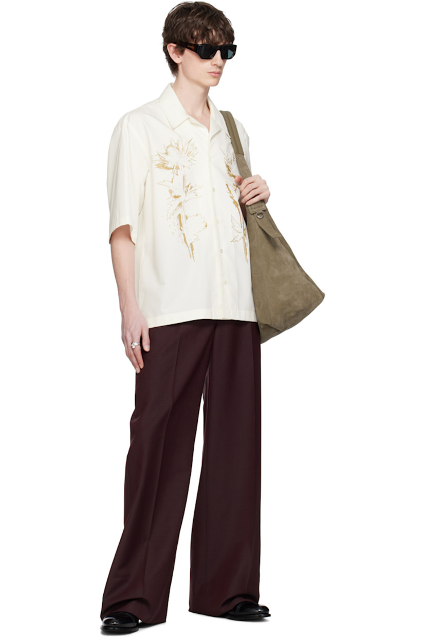 Cotton poplin shirt. 

· Open spread collar
· Button closure 
· Graphic bonded at front 
· Vented side seams
· Twin pleats at yoke 

Supplier color: Bone/Antique gold