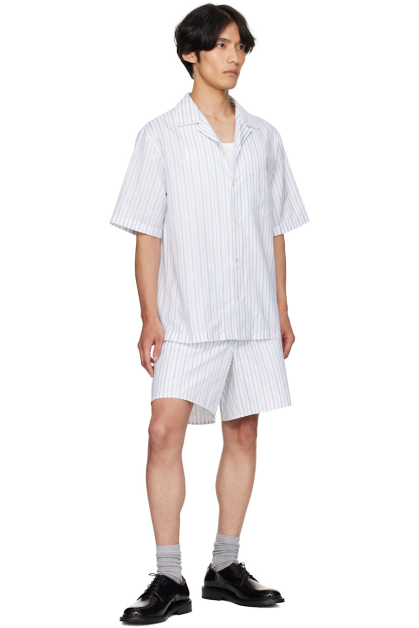 Cotton poplin shirt.

· Striped logo pattern throughout
· Open spread collar
· Button closure
· Patch pocket at chest
· Vented side seams
· Twin pleats at back yoke
· Mother-of-pearl hardware

Supplier color: White/Blue/Grey