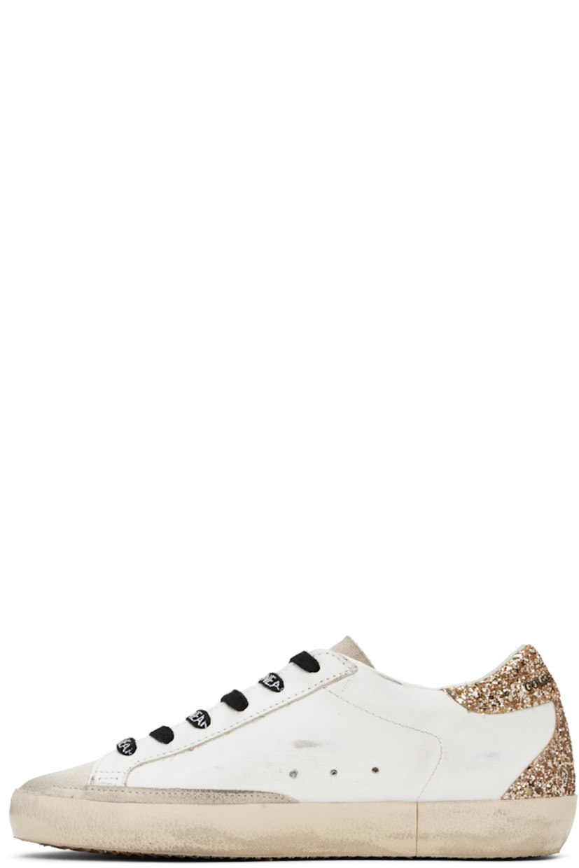 Handcrafted low-top paneled suede and buffed leather sneakers in off-white.

· Smudging and glittered detailing throughout
· Lace-up closure
· Logo stamped at tongue
· Padded collar
· Perforated detailing at sides
· Signature star appliqué at outer side
· Logo hardware at outer side
· Logo printed at heel tab
· Suede, buffed leather, and terrycloth lining
· Treaded rubber sole

Supplier color: Optic white/Seedpearl
