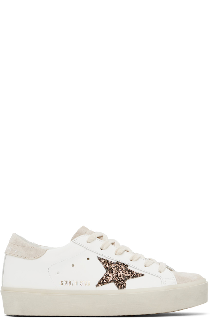 Handcrafted low-top buffed leather and suede sneakers in white and beige.

· Lace-up closure
· Logo stamp at padded tongue
· Padded collar
· Perforated detailing at sides
· Glittered signature star appliqué at outer side
· Gold-tone logo stamp at outer side
· Logo printed at heel tab
· Terrycloth, buffed leather, and suede lining
· Smudging at midsole
· Treaded rubber sole

Supplier color: White/Beige