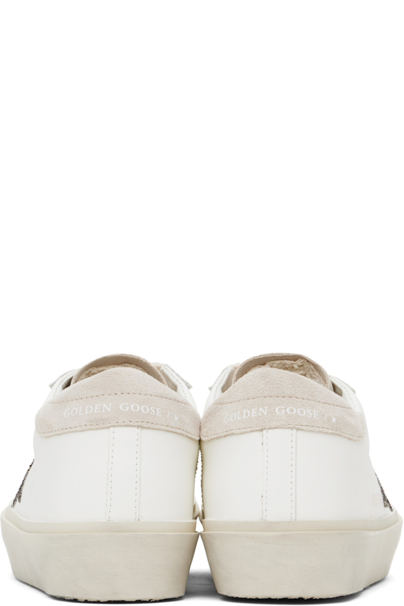 Handcrafted low-top buffed leather and suede sneakers in white and beige.

· Lace-up closure
· Logo stamp at padded tongue
· Padded collar
· Perforated detailing at sides
· Glittered signature star appliqué at outer side
· Gold-tone logo stamp at outer side
· Logo printed at heel tab
· Terrycloth, buffed leather, and suede lining
· Smudging at midsole
· Treaded rubber sole

Supplier color: White/Beige