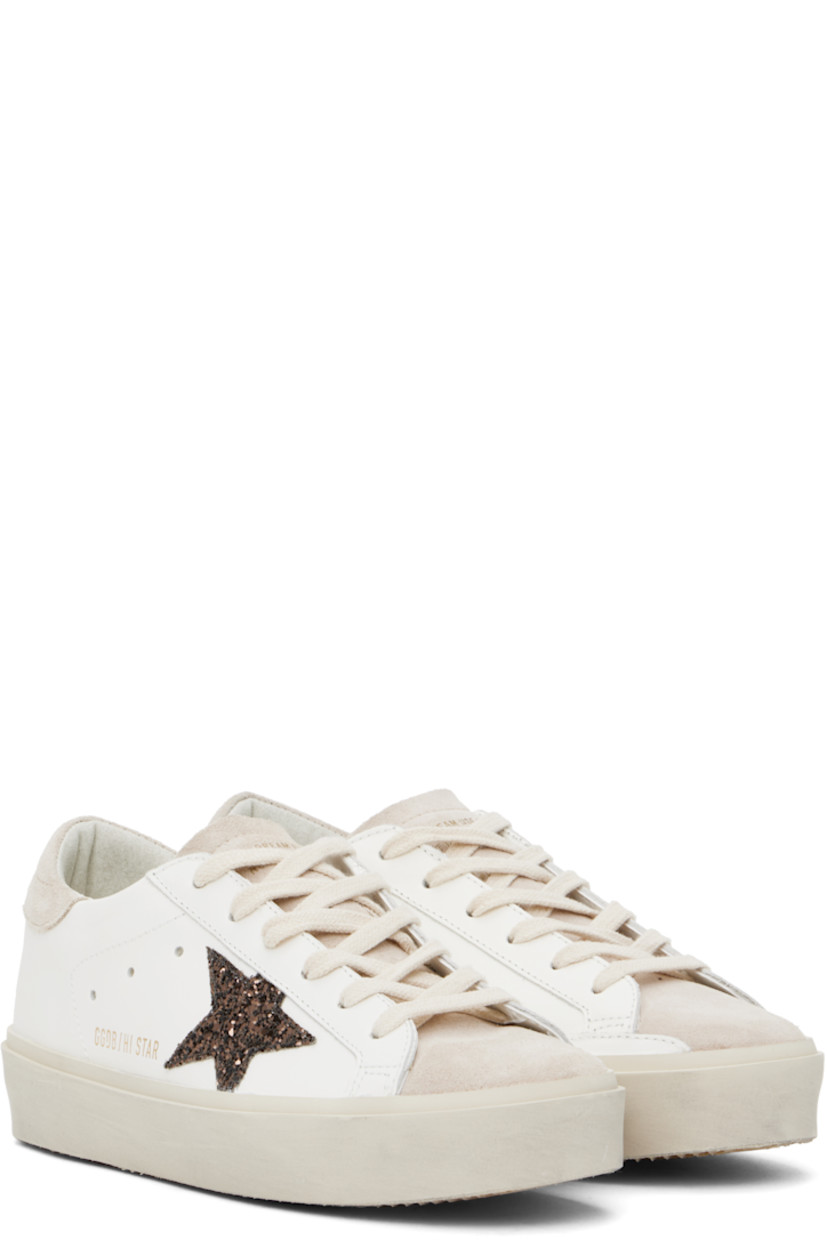 Handcrafted low-top buffed leather and suede sneakers in white and beige.

· Lace-up closure
· Logo stamp at padded tongue
· Padded collar
· Perforated detailing at sides
· Glittered signature star appliqué at outer side
· Gold-tone logo stamp at outer side
· Logo printed at heel tab
· Terrycloth, buffed leather, and suede lining
· Smudging at midsole
· Treaded rubber sole

Supplier color: White/Beige