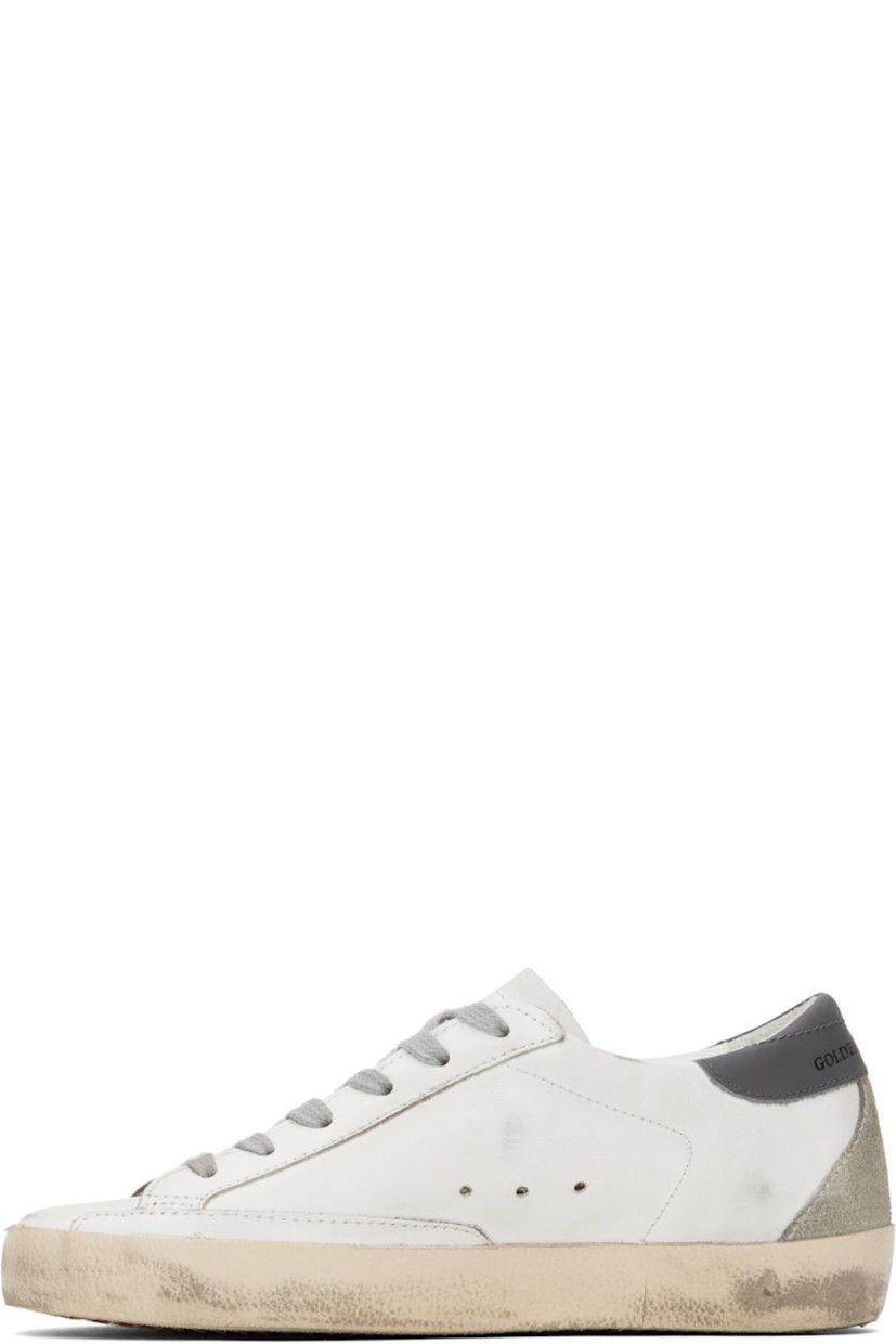 Handcrafted low-top buffed leather and suede sneakers in white and gray.

· Smudging throughout
· Lace-up closure
· Logo stamp at tongue and heel tab
· Perforated detailing at sides
· Suede signature star appliqué at outer side
· Gold-tone logo stamp at outer side
· Terrycloth, suede, and buffed leather lining
· Treaded rubber sole

Supplier color: White/Ice/Grey