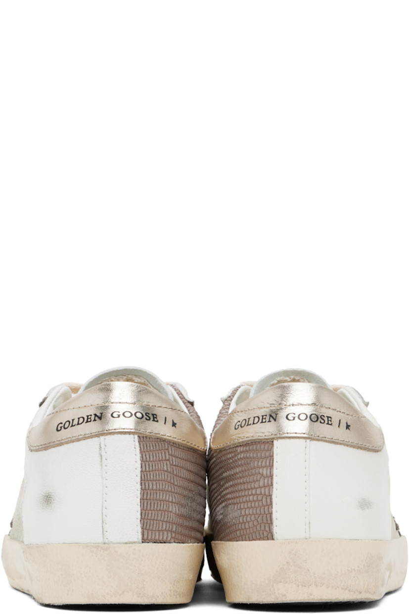 Handcrafted low-top buffed leather, suede, and snake-embossed leather sneakers in white and beige.

· Smudging throughout
· Lace-up closure
· Logo stamp at padded tongue
· Padded collar
· Star appliqué and logo stamp at outer side
· Perforated detailing at sides
· Logo printed at heel tab
· Buffed leather, suede, and terrycloth lining
· Treaded rubber sole

Supplier color: White/Light brown/Platinum