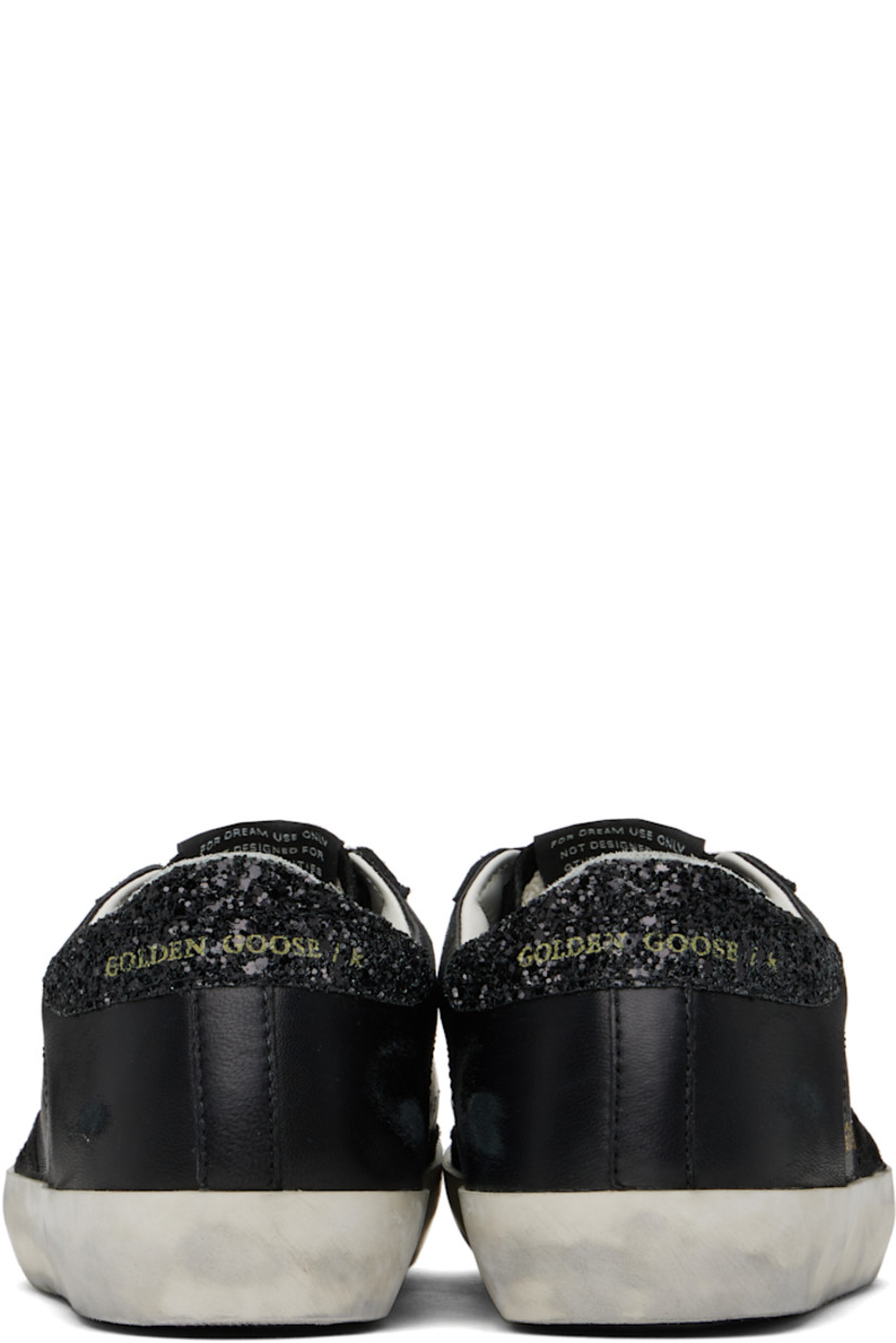 Black low-top paneled buffed sheepskin and suede sneakers in black.

· Smudging throughout
· Lace-up closure
· Logo patch at tongue
· Padded collar
· Signature star appliqué at outer side
· Gold-tone logo stamp at outer side
· Logo printed at glittered heel collar
· Terrycloth, buffed leather, and suede lining
· Treaded rubber sole

Supplier color: Black