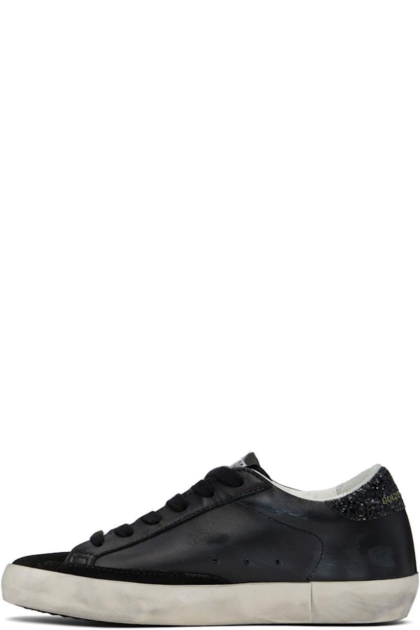 Black low-top paneled buffed sheepskin and suede sneakers in black.

· Smudging throughout
· Lace-up closure
· Logo patch at tongue
· Padded collar
· Signature star appliqué at outer side
· Gold-tone logo stamp at outer side
· Logo printed at glittered heel collar
· Terrycloth, buffed leather, and suede lining
· Treaded rubber sole

Supplier color: Black