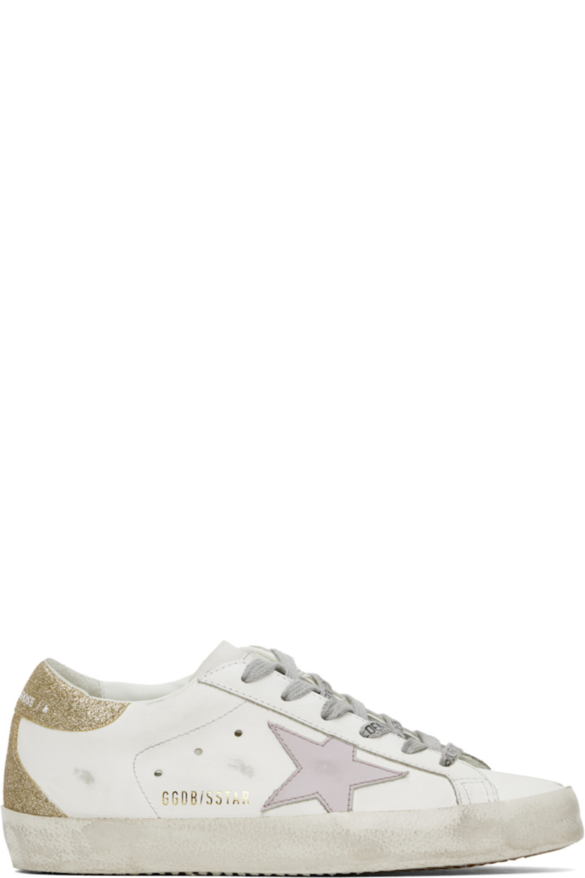 Low-top buffed leather sneakers in white, purple, and gold tone.

· Distressing and smudging throughout
· Lace-up closure
· Logo stamp at tongue
· Padded collar
· Signature star appliqué at outer side
· Logo stamp at outer side
· Perforated detailing at sides
· Logo embossed at glittered heel tab
· Buffed leather, suede, and terrycloth lining
· Textured rubber midsole
· Treaded rubber sole

Supplier color: White/Lilac/Gold