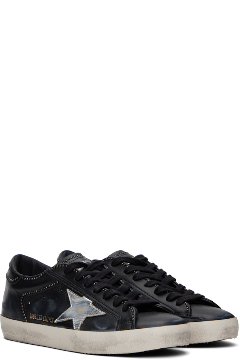 Handcrafted low-top grained nappa sheepskin sneakers in black. 

· Smudging, subtle distressing, and studs throughout 
· Lace-up closure
· Text printed at padded tongue 
· Padded collar 
· Perforations at sides
· Star appliqué and logo stamp at outer side
· Logo printed at heel tab 
· Terrycloth, suede, and buffed leather lining
· Treaded rubber sole 

Supplier color: Black/Silver