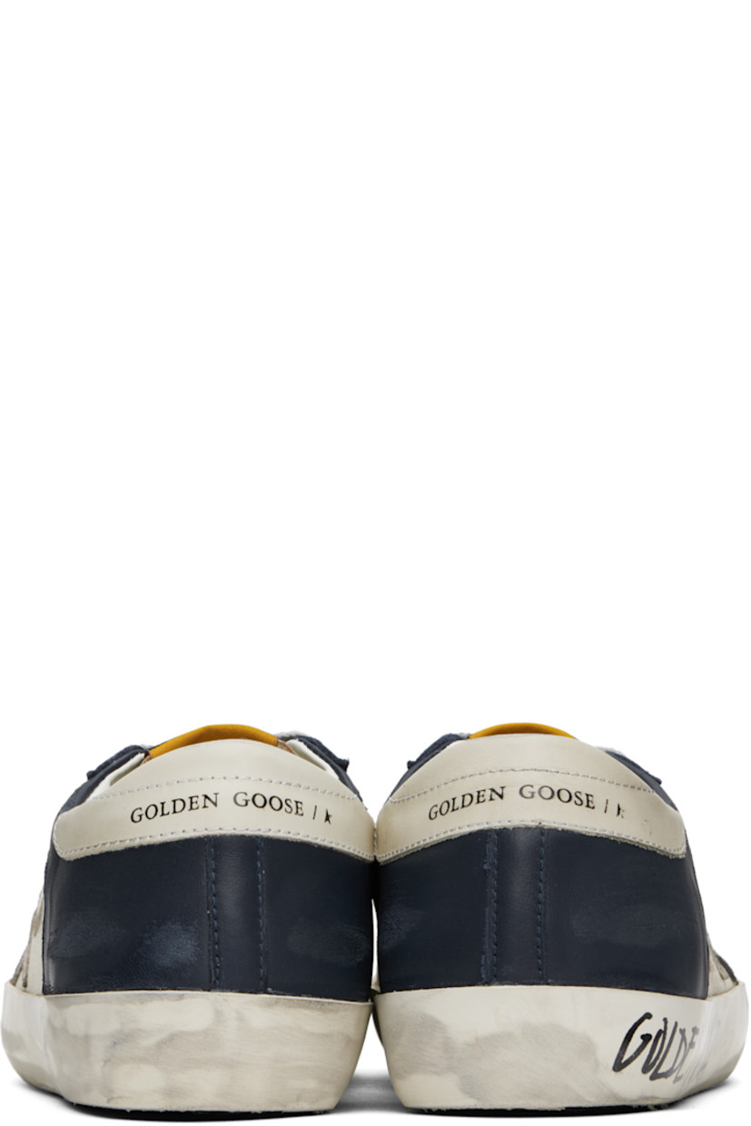 Handcrafted low-top buffed leather and nappa lambskin sneakers in white and navy.

· Smudging and subtle distressing throughout
· Lace-up closure
· Logo flag at tongue
· Padded collar
· Perforations at sides
· Star appliqué and logo stamp at outer side
· Logo printed at heel tab and midsole
· Suede, buffed faux-leather, and terrycloth lining
· Treaded rubber sole

Supplier color: White/Dark blue/Gun metal