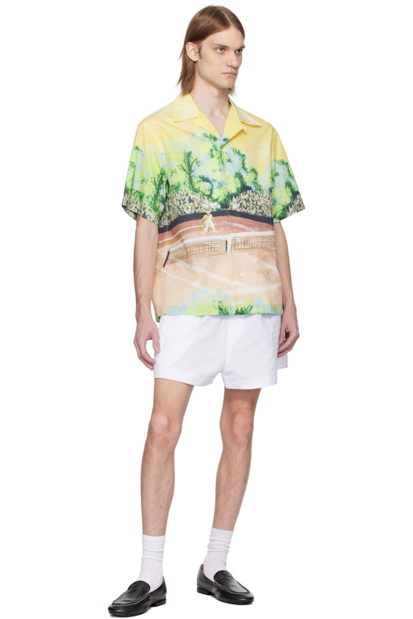 Cotton poplin shirt. Graphic printed throughout. 

· Button fastening at open spread collar
· Button closure
· Embroidered logo patch at back collar
· Twin pleats at yoke 
· Mother-of-pearl hardware

Supplier color: Yellow/Multicolor