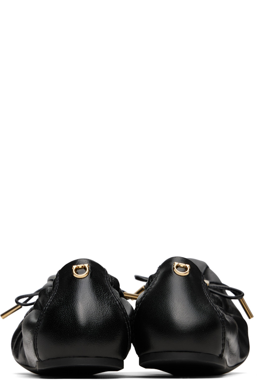 Grained nappa lambskin ballerina flats in black. 

· Pointed square toe 
· Logo charm and bow accent at vamp
· Elasticized collar
· Logo hardware at heel collar
· Lambskin lining
· Treaded rubber sole 
· Gold-tone hardware

Supplier color: Black