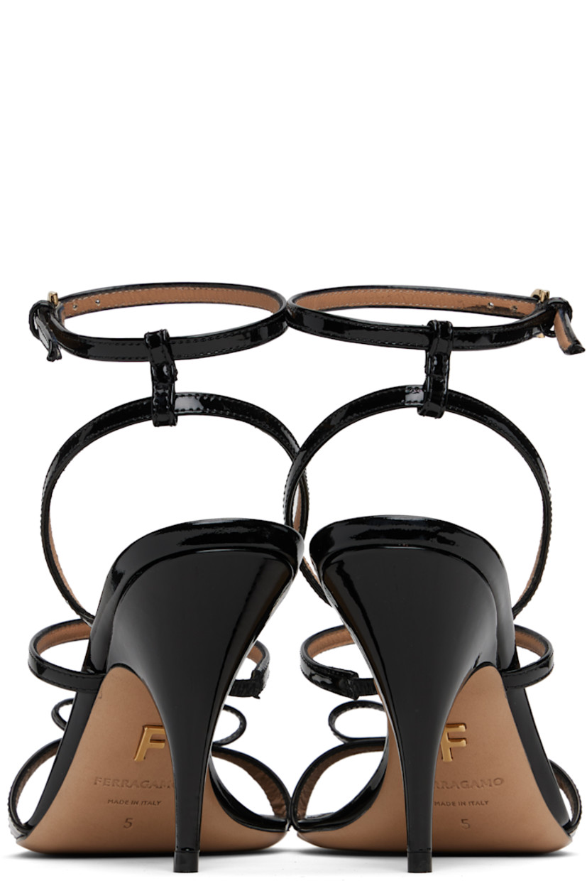 Patent leather heeled sandals.

· Open toe 
· Straps and logo-engraved bow accent at vamp
· Adjustable pin-buckle ankle strap
· Logo stamp at padded footbed
· Covered stiletto heel 
· Leather sole with rubber injections
· Logo hardware at sole
· Gold-tone hardware
· Heel: H3.5"

Supplier color: Nero/Vernice nero