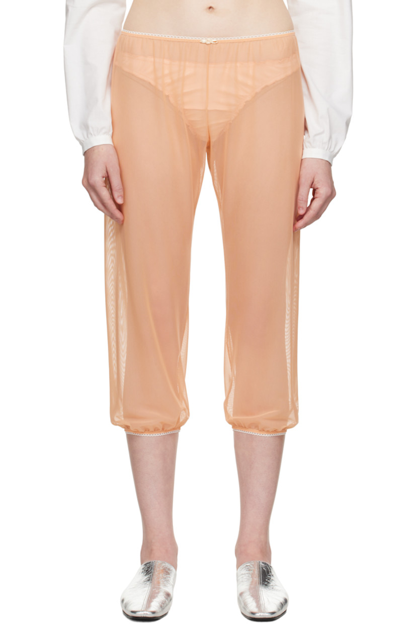 Sheer nylon tulle trousers.

· Scalloped edge at elasticized waistband and cuffs
· Floral appliqué at front waistband
· Cropped legs

Supplier color: Peach