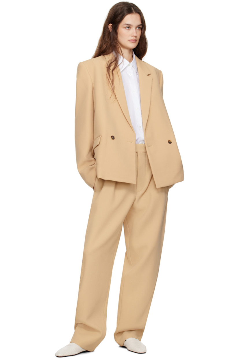 Virgin wool twill blazer.

· Notched lapel
· Double-breasted button closure
· Flap pockets
· Padded shoulders
· Central vent at back hem
· Welt pocket at interior
· Full viscose satin lining

Part of the WARDROBE.NYC x Hailey Bieber collaboration.

Supplier color: Biscuit