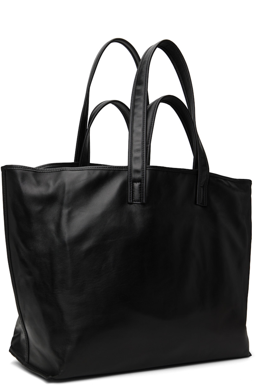 Buffed calfskin tote in black.

· Fixed carry handles and shoulder straps
· Lanyard-clasp closure
· Flap and zip pocket at interior
· Buffed leather, suede, and faille lining
· H14" x W24" x D8"

Supplier color: Black
