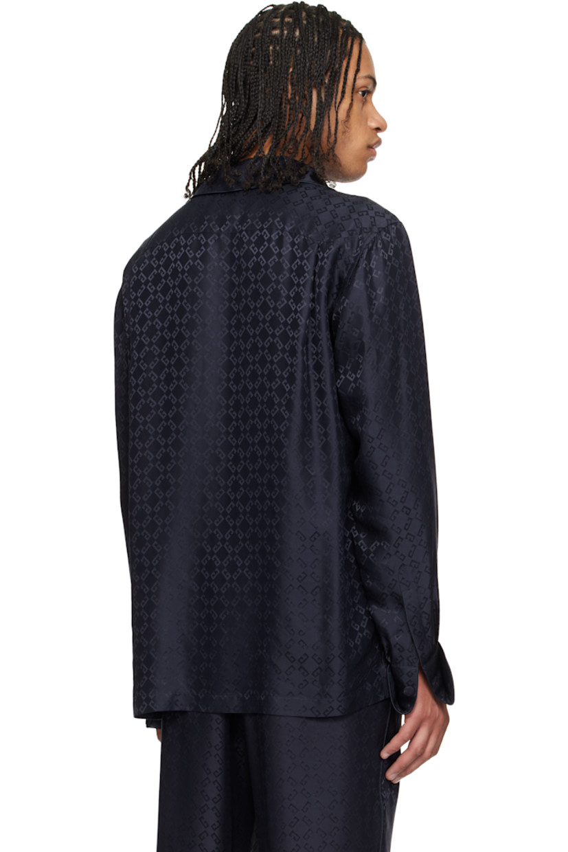 Loose-fit silk poplin pyjama shirt. Piping and jacquard logo pattern throughout.

· Open spread collar
· Button closure
· Patch pockets
· Vented side seams
· Dropped shoulders
· Pleats at single-button barrel cuffs
· Twin pleats at back yoke

Supplier color: Dark blue