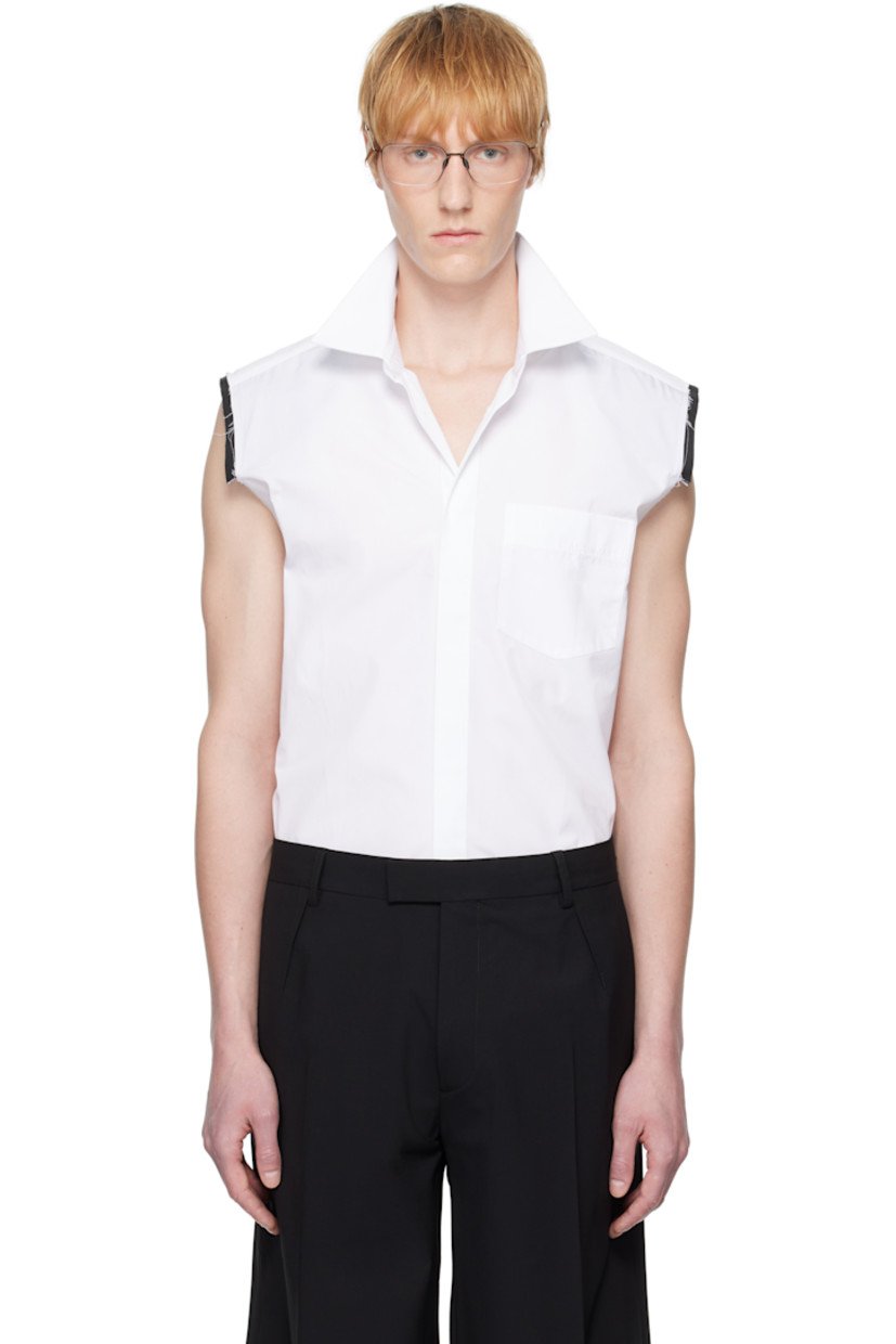 Cotton poplin shirt. 

· Spread collar
· Button closure
· Logo embroidered at patch pocket
· Shirttail hem
· Exposed layered trim at shoulders
· Raw edge at armscyes
· Box pleat at back yoke
· Mother-of-pearl hardware

Supplier color: White
