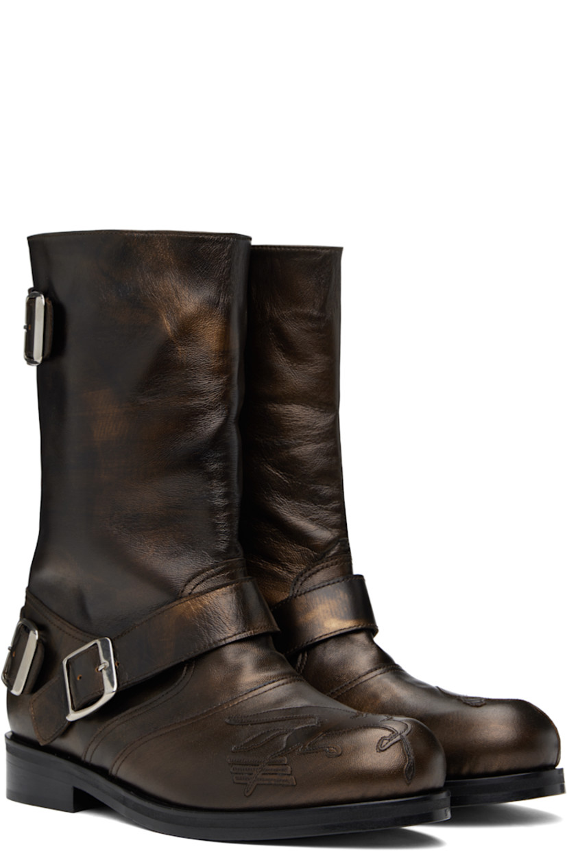 Mid-calf buffed leather slip-on boots in metallic brown. Pin-buckle straps at vamp, outer side, and heel counter.

· Graphic appliqué at toe
· Stacked leather heel with rubber injection
· Polished leather sole

Supplier color: Brown