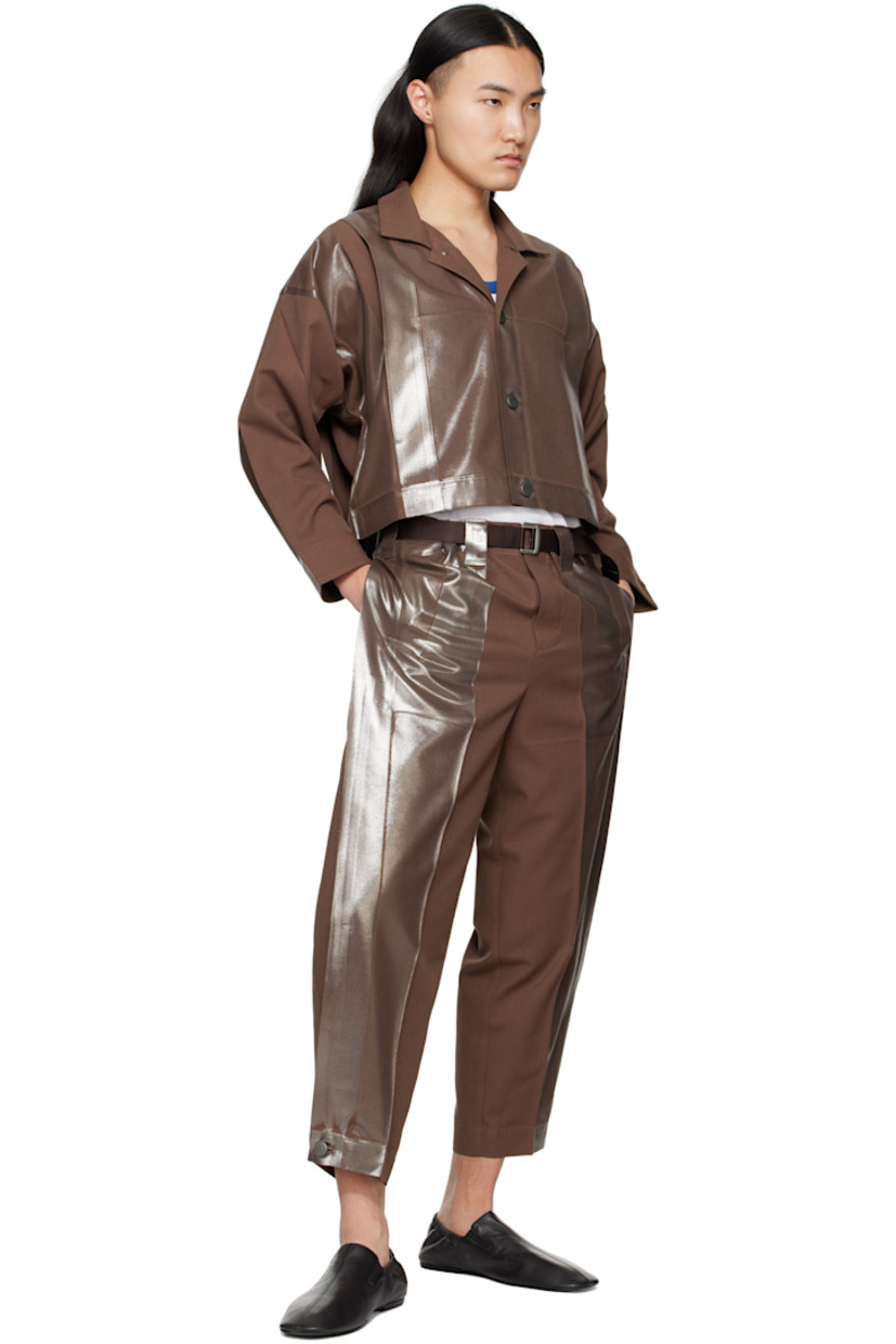 Foil-coated polyester- and cotton-blend twill trousers.

· Tapered leg
· Belt loops
· Detachable webbing cinch belt
· Two-pocket styling
· Button fly
· Creased legs
· Button fastening at cuffs
· Tuck at outseams

Supplier color: Brown