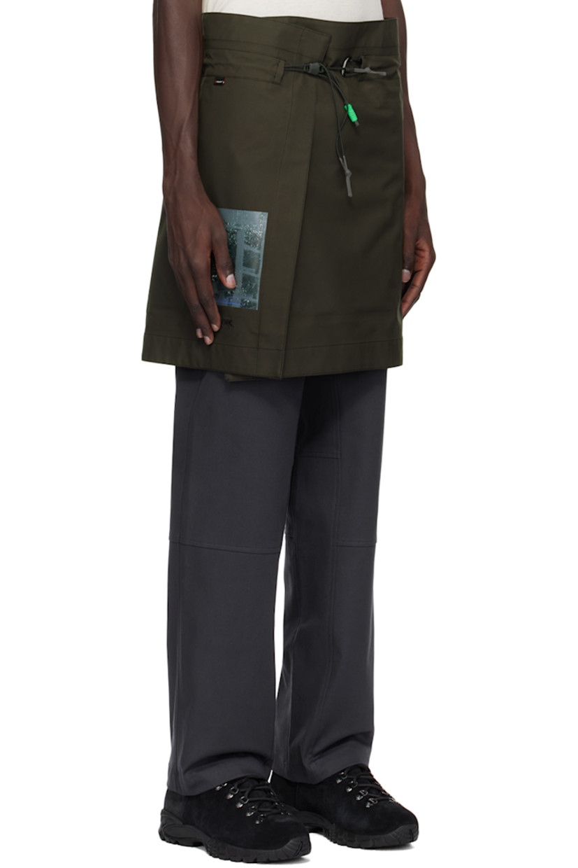 Polyurethane-coated plain-woven Polartec® polyester skirt.

· Wrap construction 
· Drawstring with carabiner at elasticized waistband
· Printed graphic and embroidered logo at front 
· Full fleece lining

Available exclusively at SSENSE.

Supplier color: Dark soil grey