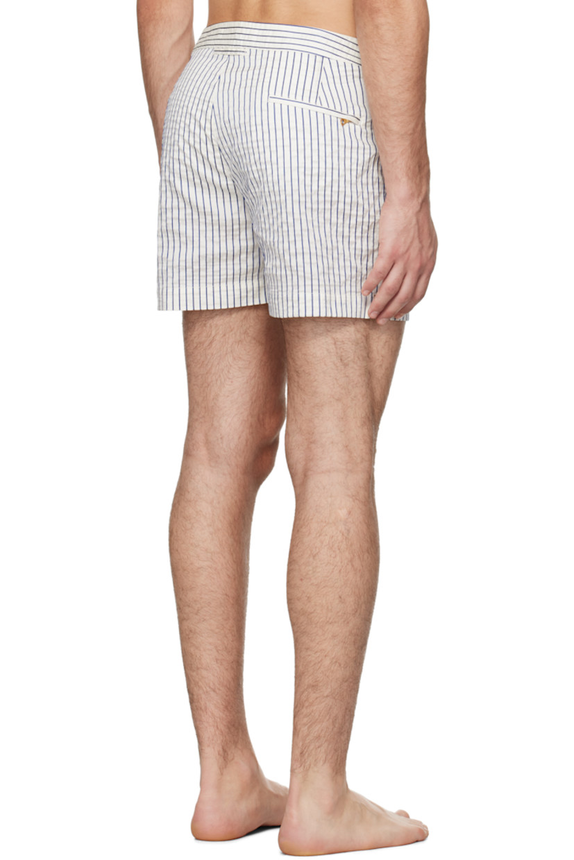 Crinkled stretch polyester canvas swim shorts. Stripes throughout.

· Three-pocket styling
· Zip-fly
· Vented cuffs
· Cinch strap at waistband outseams
· Logo flag at outseam
· Locker loop at back
· Briefs-style mesh lining

Supplier color: White sand/River blue