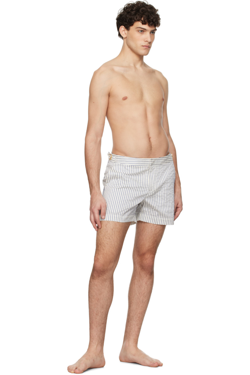 Crinkled stretch polyester canvas swim shorts. Stripes throughout.

· Three-pocket styling
· Zip-fly
· Vented cuffs
· Cinch strap at waistband outseams
· Logo flag at outseam
· Locker loop at back
· Briefs-style mesh lining

Supplier color: White sand/River blue