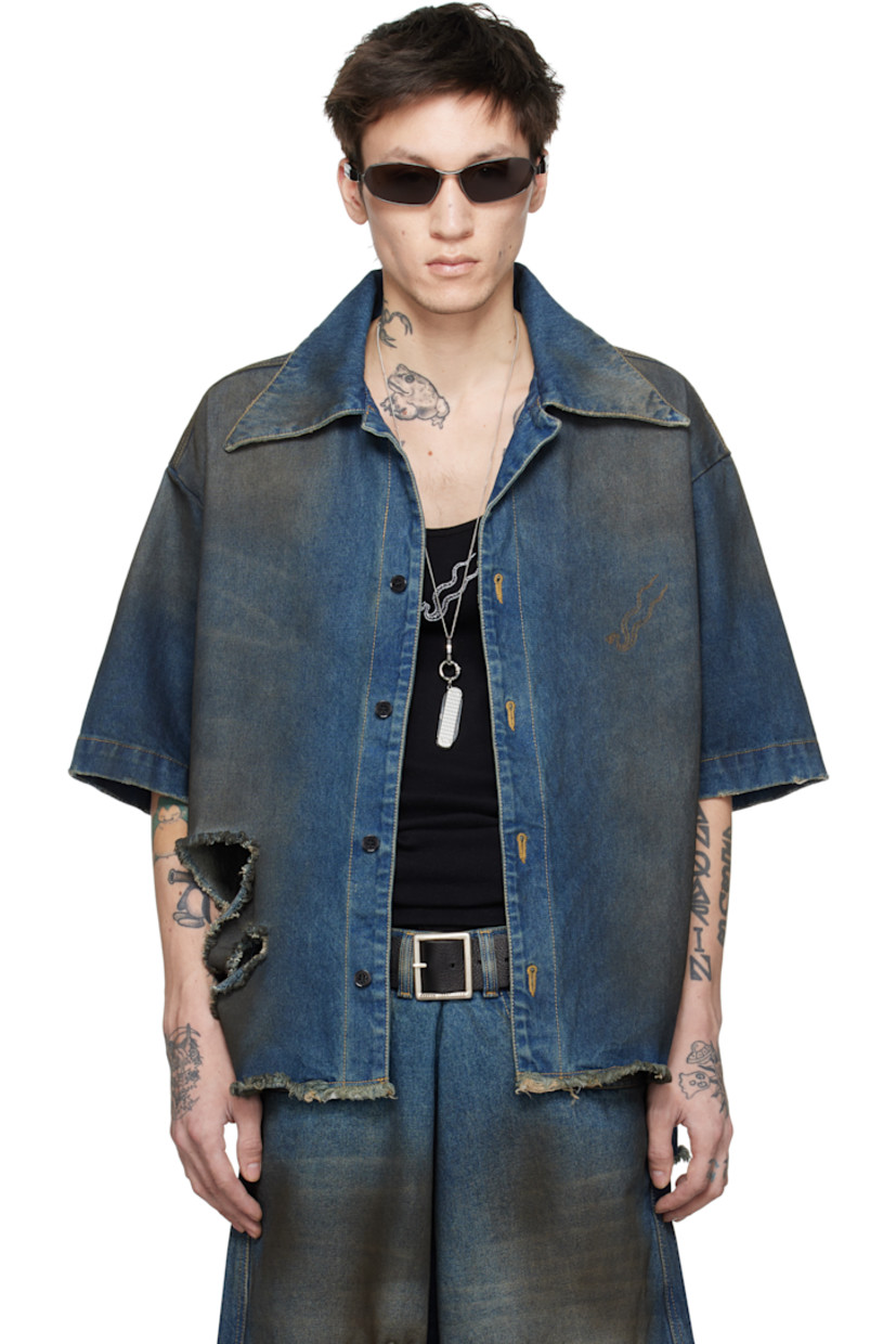 Non-stretch denim shirt. Smudging, fading, and distressing throughout.

· Open spread collar
· Button closure
· Logo embroidered at front
· Rips at front
· Raw edge at hem
· Vented side seams
· Box pleat at back yoke
· Contrast stitching in beige

Supplier color: Dirty blue