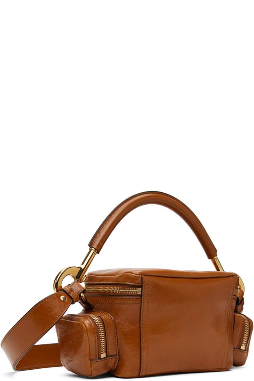 LWG-certified polished grained buffalo leather shoulder bag in tan. 

· Detachable rolled carry handle
· Detachable and adjustable crossbody strap
· Pin-buckle flap pocket at face
· Zip pocket at sides
· Two-way zip closure
· Patch pocket at interior
· Cotton- and linen-blend canvas lining
· Logo-engraved gold-tone hardware
· H5" x W7.5" x D4"

Supplier color: Clay brown
