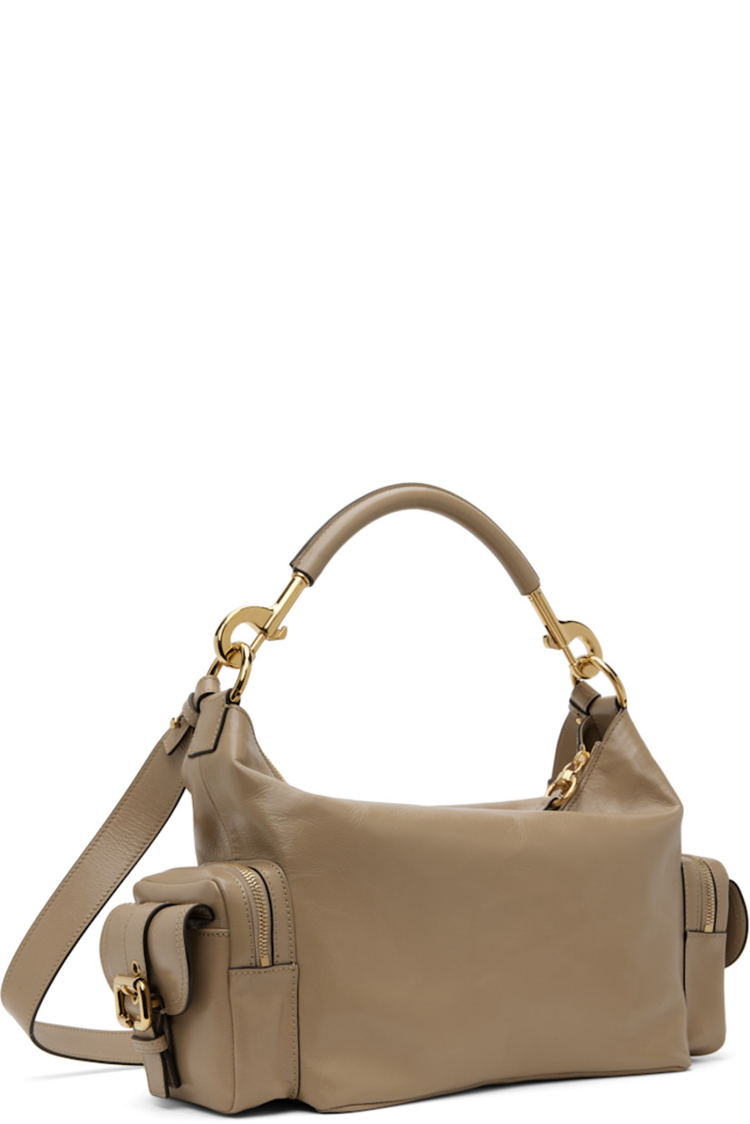 LWG-certified polished buffalo leather shoulder bag in taupe. 

· Detachable rolled carry handle
· Detachable and adjustable crossbody strap
· Pin-buckle flap pocket at face and sides
· Zip pocket at sides
· Two-way zip closure
· Patch pocket at interior
· Cotton- and linen-blend canvas lining
· Logo-engraved gold-tone hardware
· H9" x W15" x D6"

Supplier color: Boyish brown