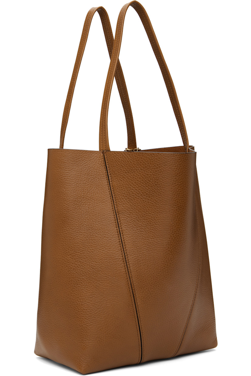 Grained leather tote in brown.

· Twin carry handles
· Detachable logo charms at handle base
· Logo stamp at face
· Lanyard clasp at interior
· H12" x W10.5" x D5.5"

Supplier color: Clay brown