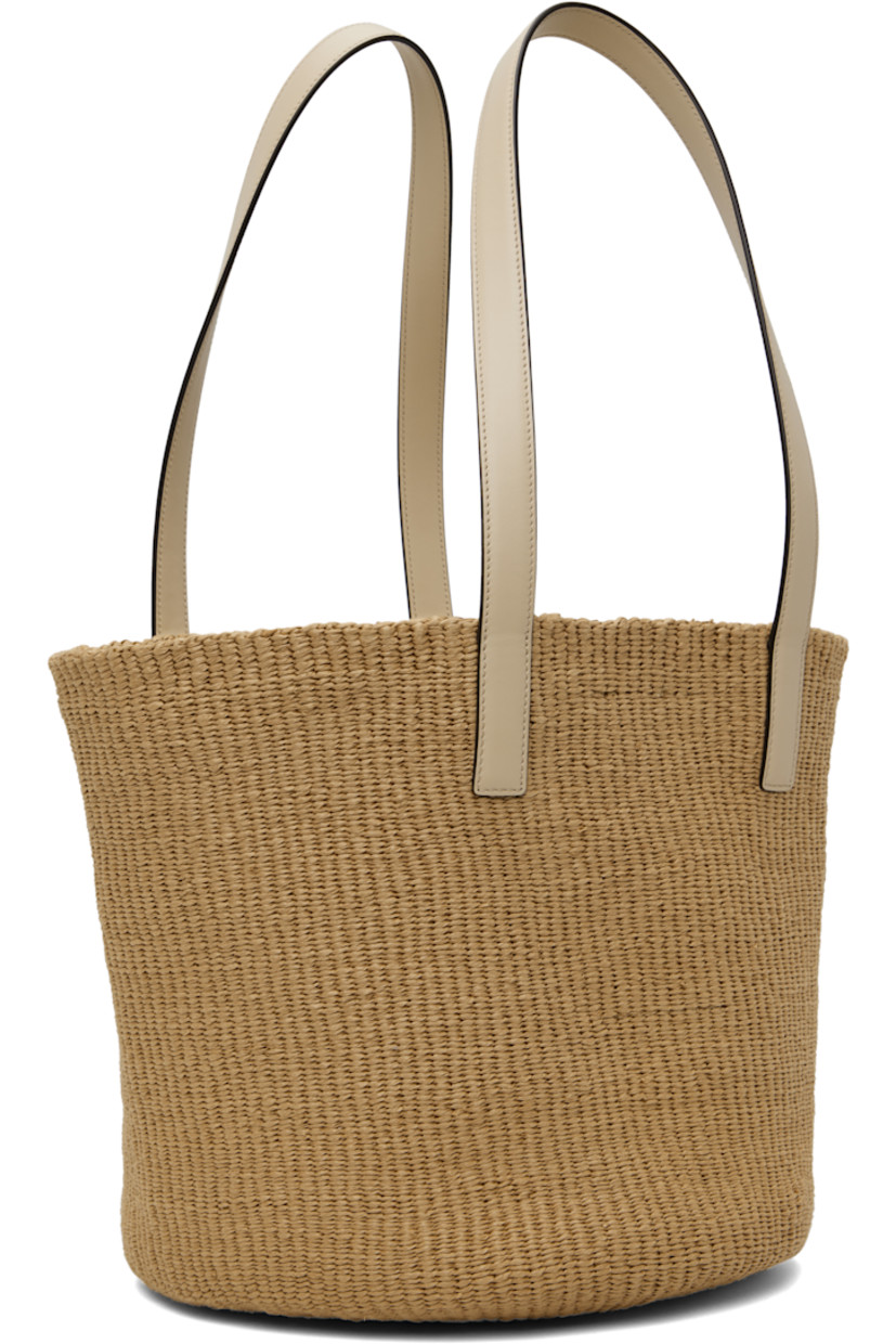 Woven paper tote in beige.

· Buffed calfskin trim in off-white throughout
· Fixed shoulder straps
· Logo patch at face
· Logo embossed at base
· H11" x W12" x D11"

Supplier color: Deep ivory