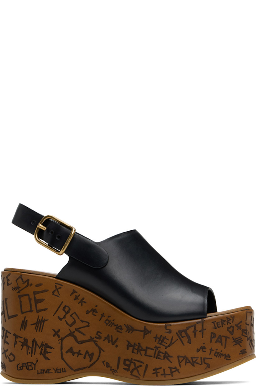 Vegetable-tanned buffed calfskin heeled sandals in black.

· LWG-certified
· Open toe
· Pin-buckle slingback strap
· Logo embossed at calfskin footbed
· Text etched at covered platform midsole and wedge heel
· Crêpe rubber sole
· Logo-engraved antiqued gold-tone hardware
· Platform: H2"
· Heel: H4"

Supplier color: Black