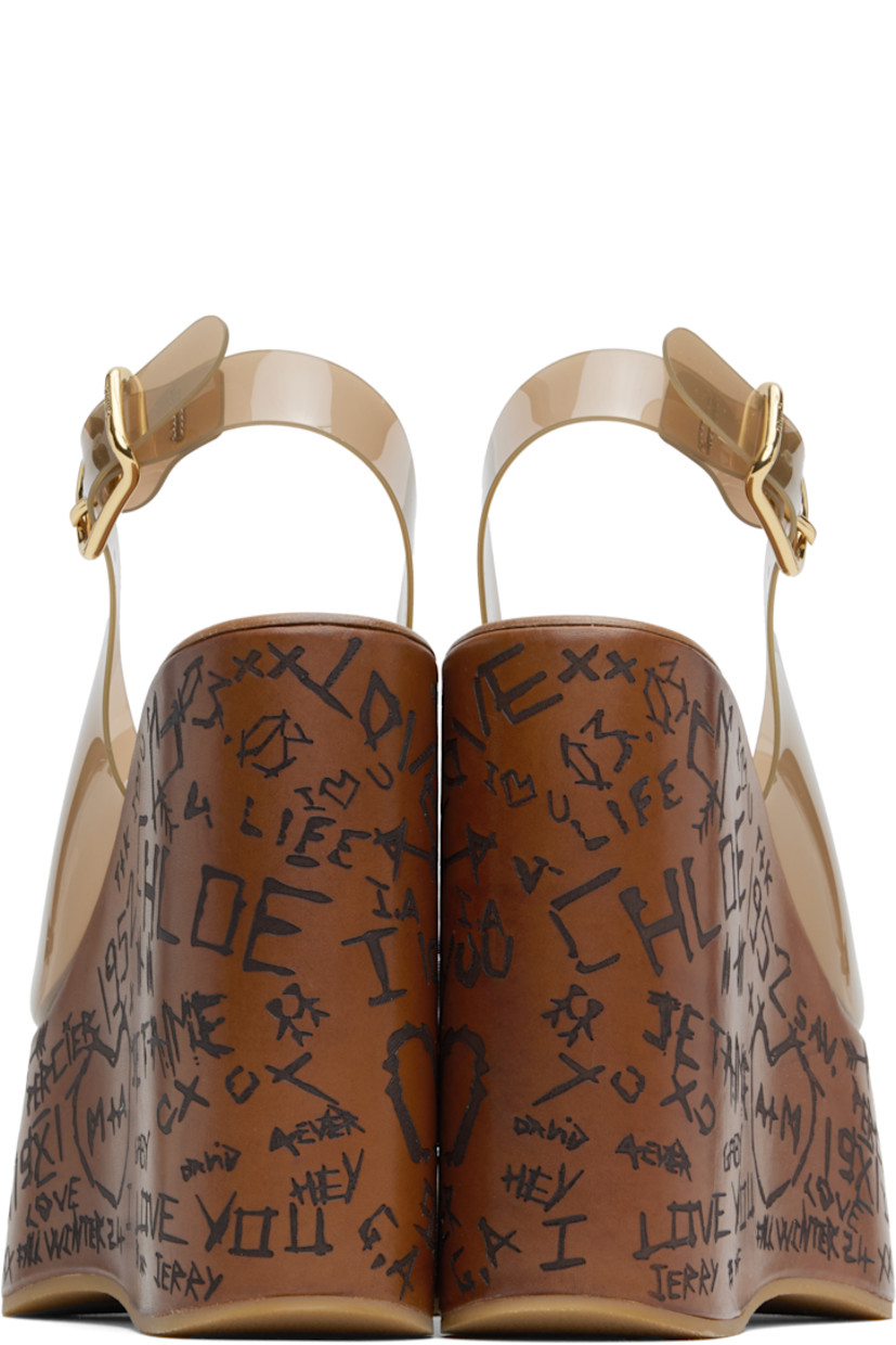 Transparent vinyl heeled sandals in brown.

· Open toe
· Pin-buckle slingback strap
· Logo embossed at leather footbed
· Text etched at covered platform midsole and wedge heel
· Crêpe rubber sole
· Logo-engraved antiqued gold-tone hardware
· Platform: H2.25"
· Heel: H5"

Supplier color: Sunny brown