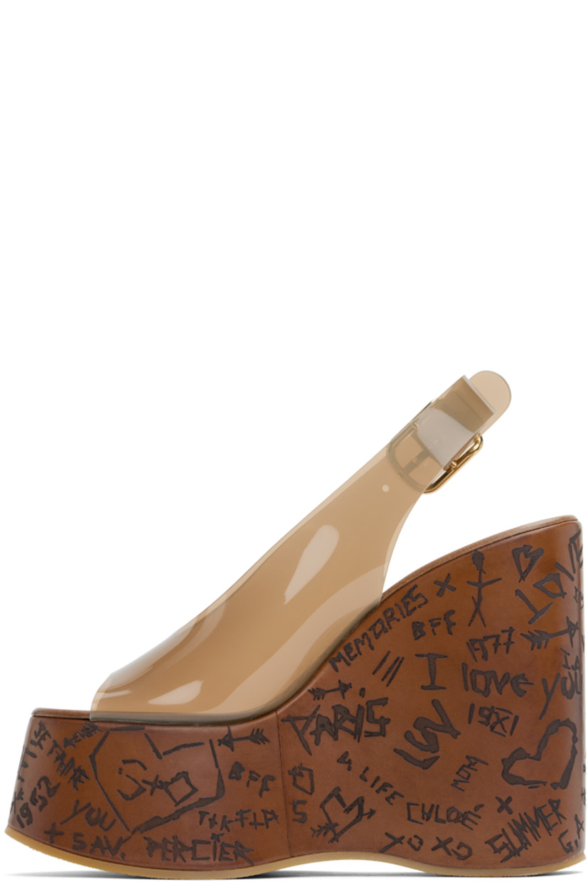 Transparent vinyl heeled sandals in brown.

· Open toe
· Pin-buckle slingback strap
· Logo embossed at leather footbed
· Text etched at covered platform midsole and wedge heel
· Crêpe rubber sole
· Logo-engraved antiqued gold-tone hardware
· Platform: H2.25"
· Heel: H5"

Supplier color: Sunny brown