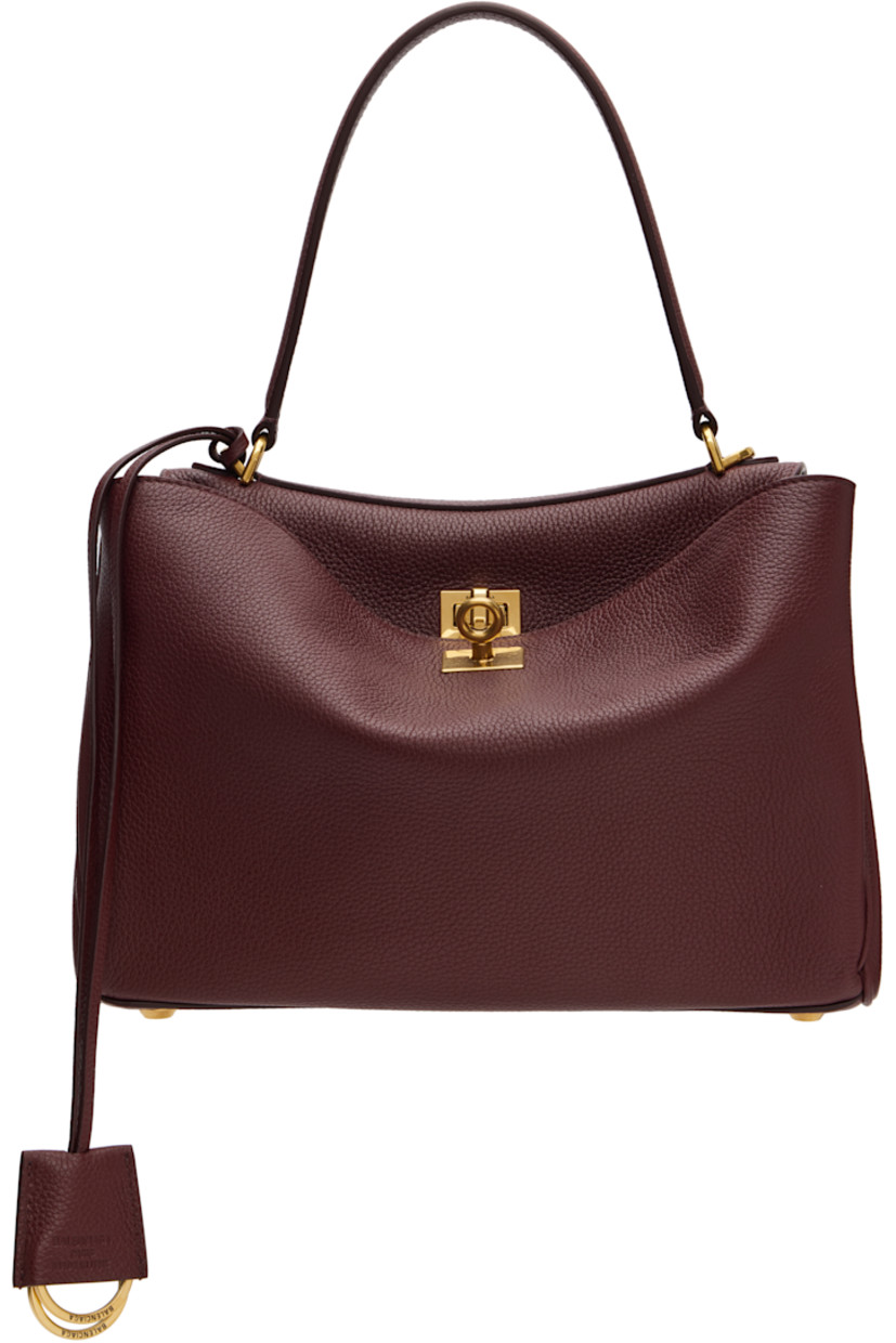Grained calfskin top handle bag.

· Fixed carry handle
· Detachable crossbody strap
· Detachable leather lanyard with key rings
· Press-stud fastening at sides
· Patch pockets at back face
· Bumper studs at base
· Turn-lock flap closure
· Zip pocket at two-compartment interior
· Nappa lambskin lining
· Logo-engraved antiqued gold-tone hardware
· H9" x W10.75" x D4"

Supplier color: Dark Burgundy