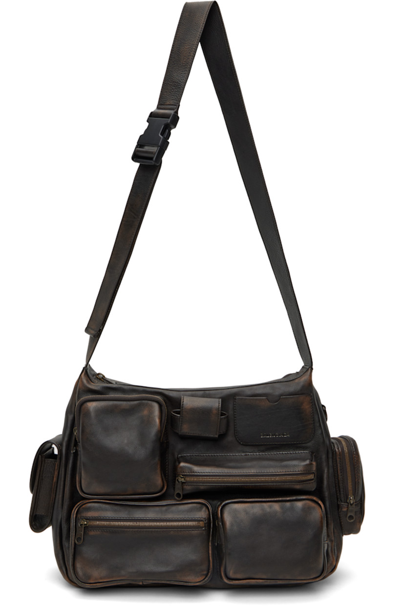 Grained calfskin messenger bag in brown.

· Fading throughout
· Flap and zip pockets throughout
· Adjustable crossbody strap
· Silver-tone logo stamp at face and back
· Card slot and AirPods Pro compartment at face
· Zip pocket at back face
· Zip closure
· Cotton canvas lining
· Logo-engraved antiqued gold-tone hardware
· H10" x W13" x D4"

Supplier color: Brown