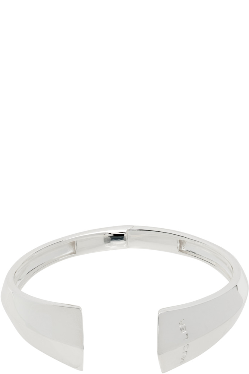 Open-cuff bracelet in silver-tone brass.

· Logo engraved at front
· Spring-hinged
· W2.5"

Supplier color: Silver