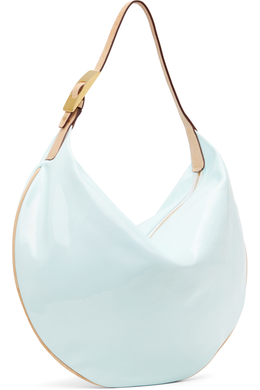 Patent leather shoulder bag in blue.

· Adjustable grained leather shoulder strap
· Zip closure
· Faux-suede lining
· Gold-tone hardware
· H13" x W17" x D3.5"

Supplier color: Frozen blue