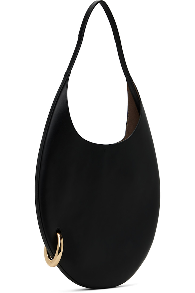Buffed leather shoulder bag in black.

· Fixed shoulder strap
· Gold-tone O-ring at side
· Self-tie closure
· Zip pocket at interior
· Faux-suede lining
· H12" x W12.5" x D1"
· Total height: H23"
 
Supplier color: Black/Gold